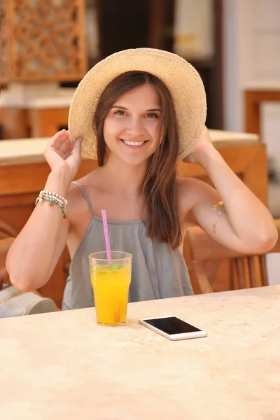 Beautiful young woman drinking lemonade in cafe — Stock Photo, Image