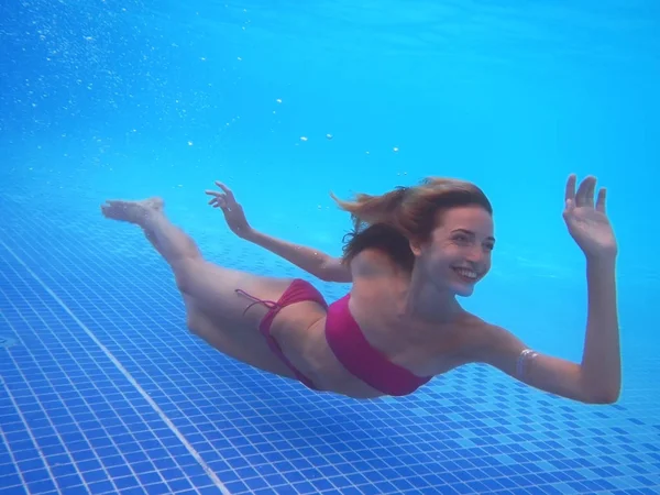 Mujer joven nadando bajo el agua — Foto de Stock