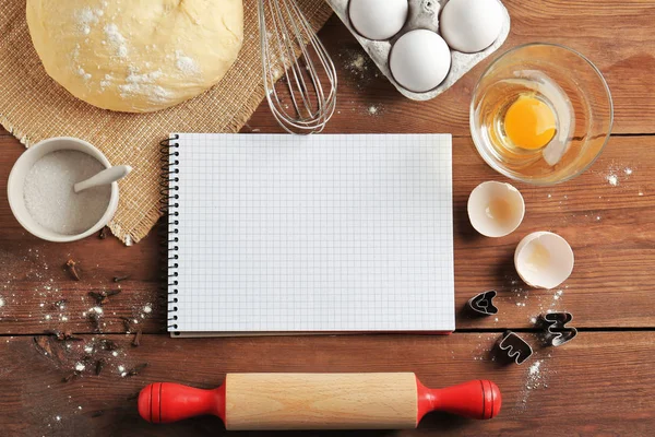 Cuaderno y masa cruda con ingredientes en la mesa de la cocina. Concepto de clases de cocina —  Fotos de Stock