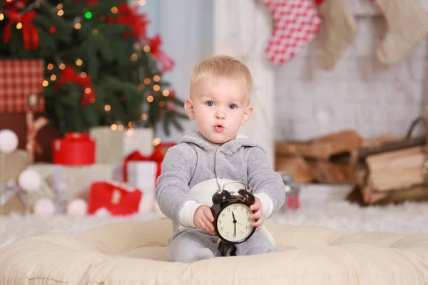 Schattige kleine baby met klok thuis. Christmas countdown concept — Stockfoto