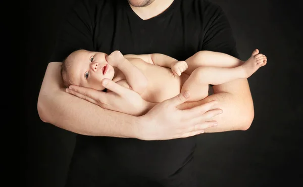 黒い背景に新生児を持つ父親 — ストック写真