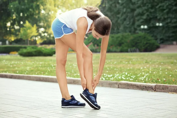 Fiatal sportos nő odakötő cipőfűzők szabadban — Stock Fotó