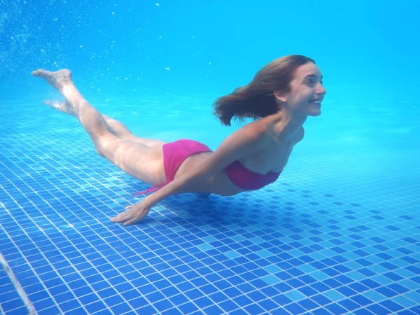 Jonge vrouw onder water zwemmen — Stockfoto