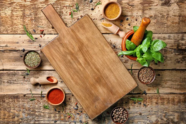 Composition with cutting board, spices and herbs on wooden background — Stock Photo, Image