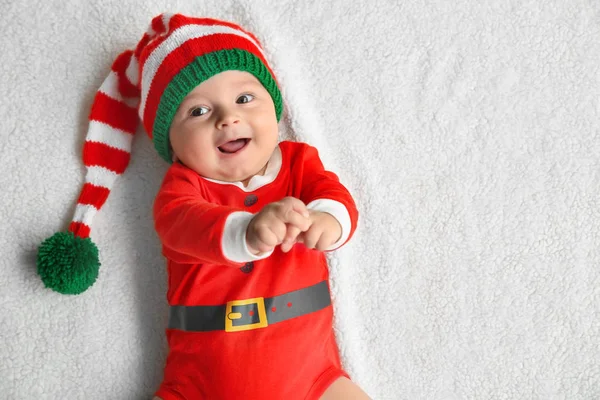 Schattige kleine baby in Santa kostuum liggend op zachte stof — Stockfoto