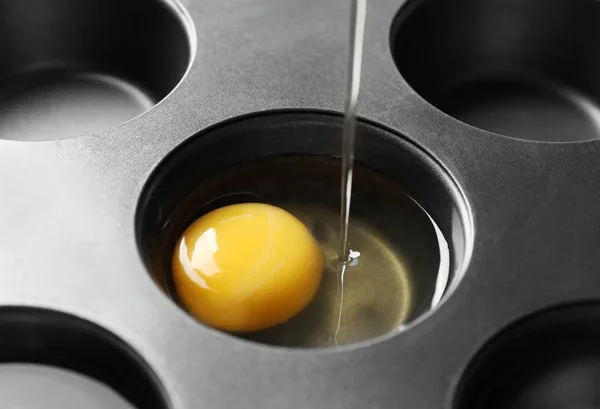 Despejar ovo cru em lata de muffin, close-up — Fotografia de Stock