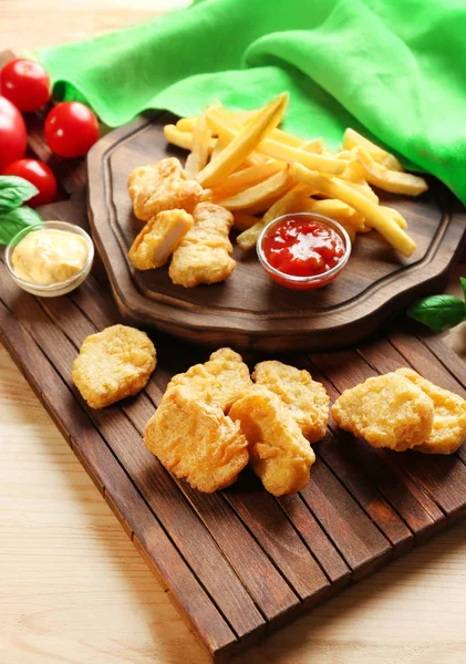 Smakelijke nuggets, frietjes en sauzen — Stockfoto