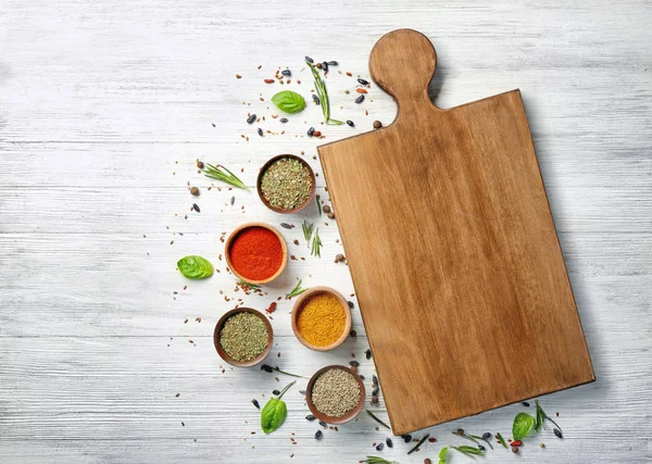 Composition with cutting board, spices and herbs on wooden background — Stock Photo, Image