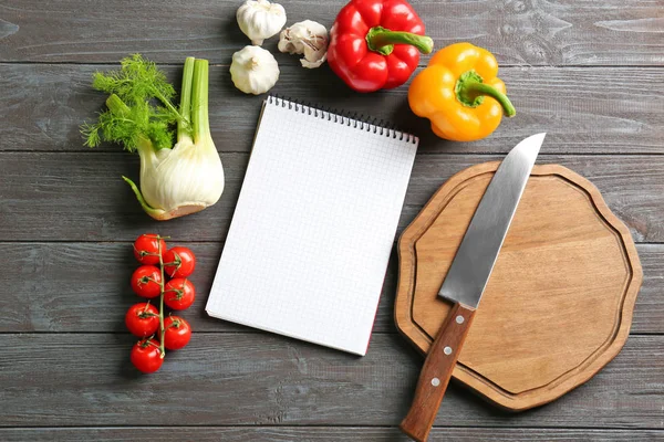 Notebook a zelenina na kuchyňském stole. Vaření třídy koncepce — Stock fotografie