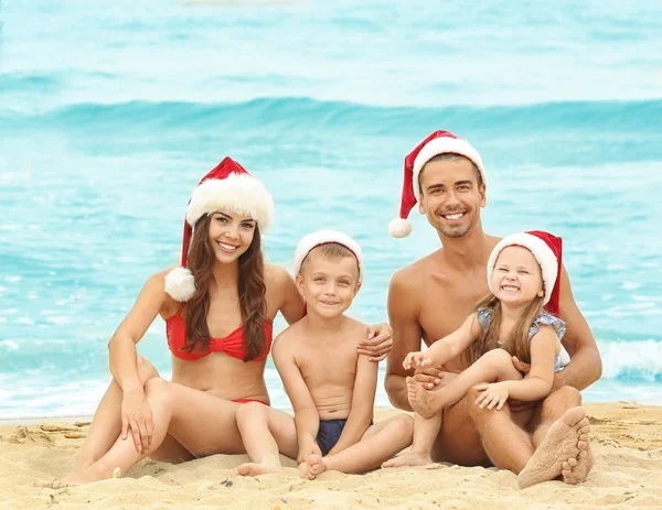 Pareja joven con niños en la playa. Concepto de Navidad —  Fotos de Stock