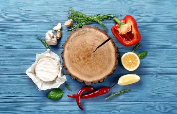 Composition avec plateau en bois, fromage à pâte molle et légumes sur la table — Photo