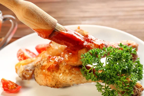 Spreading tasty tomato sauce on chicken legs — Stock Photo, Image