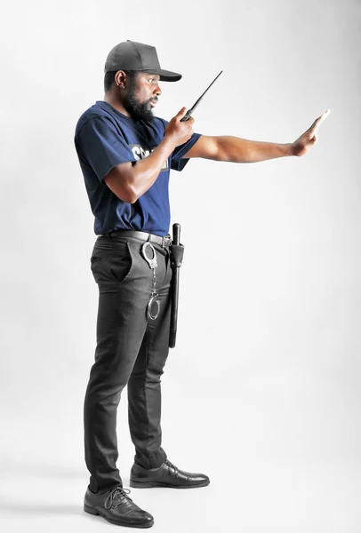 Protetor de segurança masculino mostrando gesto de parada ao usar rádio portátil, no fundo branco — Fotografia de Stock