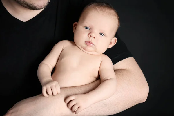 Ojciec trzymający noworodka na czarnym tle — Zdjęcie stockowe