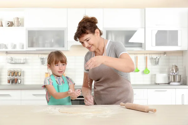 Liten flicka och mormor på kök — Stockfoto