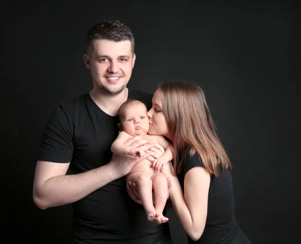 Mutlu genç aile siyah arka plan üzerine yeni doğan holding — Stok fotoğraf
