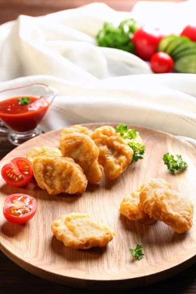 Smakelijke nuggets en jus boot met saus voor kip op tafel — Stockfoto