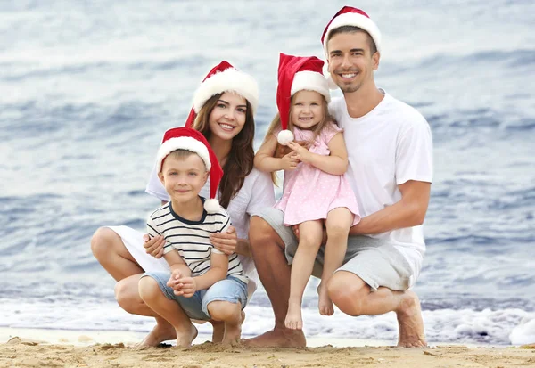Unga par med barn på stranden. Jul-konceptet — Stockfoto
