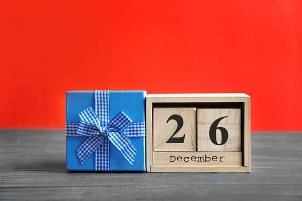 Calendar with date and gift box on color background. Christmas concept — Stock Photo, Image