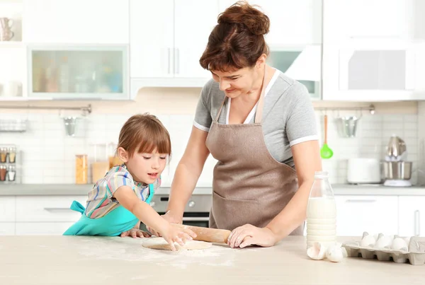 Маленькая девочка и бабушка на кухне — стоковое фото