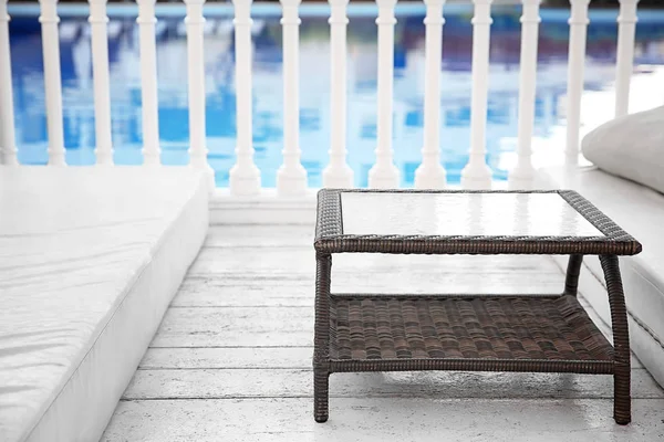 Rattan table near swimming pool