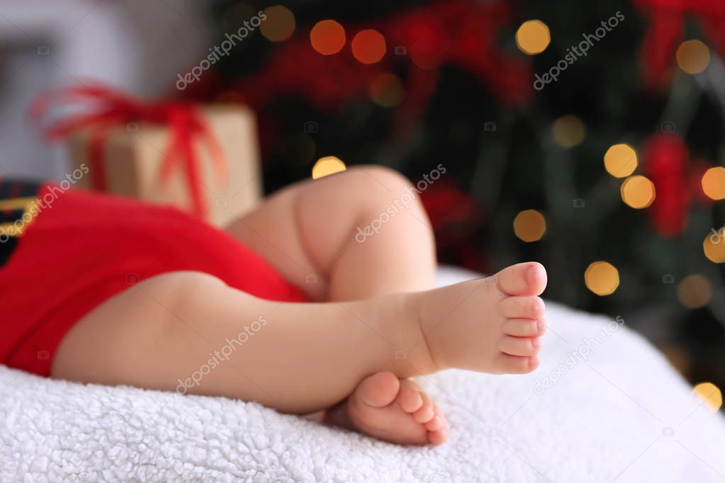 Cute little baby sleeping against blurred Christmas lights