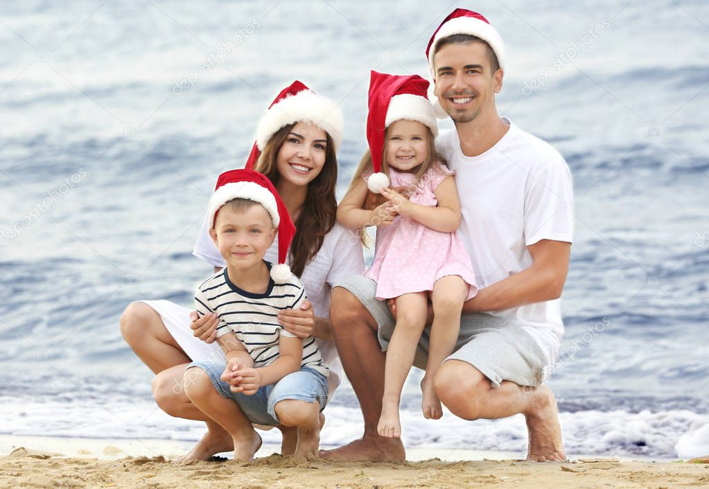 Young couple with children on beach. Christmas concept