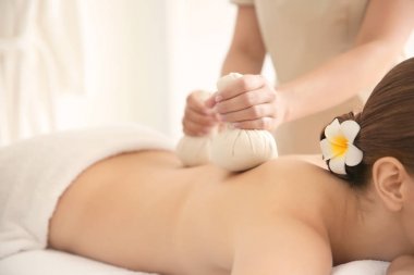 Sırt masajı bitkisel çanta ile sahip güzel ve genç birbayan