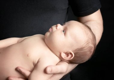Siyah arka planda, closeup yeni doğan holding baba