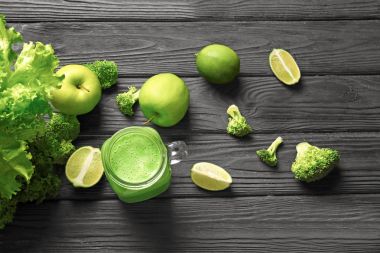 Mason kavanoza ahşap masa üzerinde taze yeşil smoothie ile