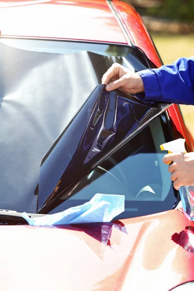 Trabajador aplicando lámina de teñido en el coche — Foto de Stock