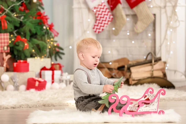 Cute little baby with toys in room decorated for Christmas — Stock Photo, Image