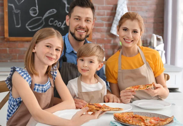 Семья ест вкусную пиццу вместе на кухне. Концепция кулинарных курсов — стоковое фото