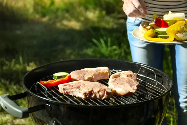 Donna che prepara bistecche barbecue — Foto Stock