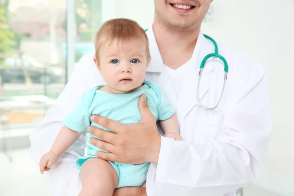 男性儿科医生抱着漂亮的女婴在室内 — 图库照片