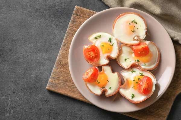 Assiette avec de savoureux œufs au jambon sur la table — Photo