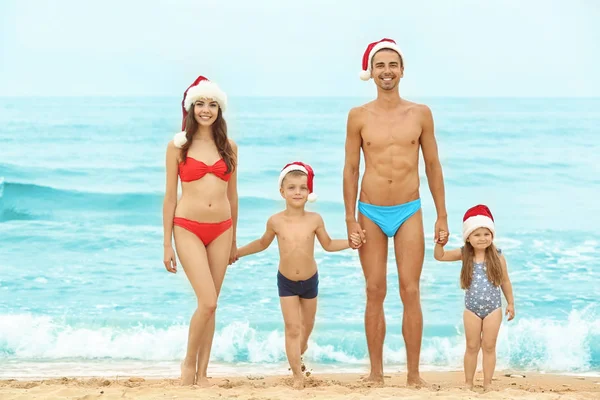 Casal jovem com crianças na praia. Conceito de Natal — Fotografia de Stock