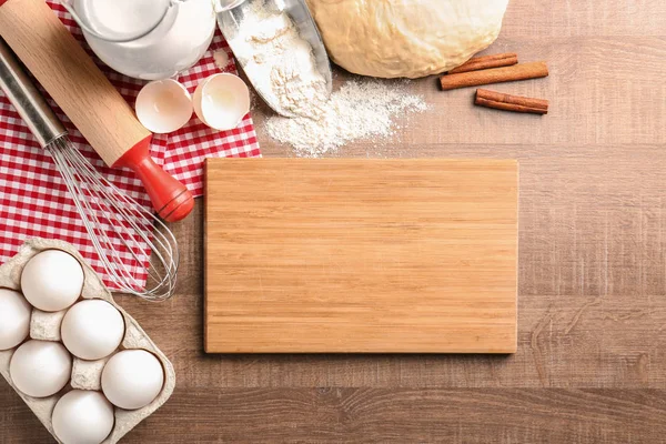 Houten plank en ruwe deeg met ingrediënten op de keukentafel. Kokende klassen concept — Stockfoto