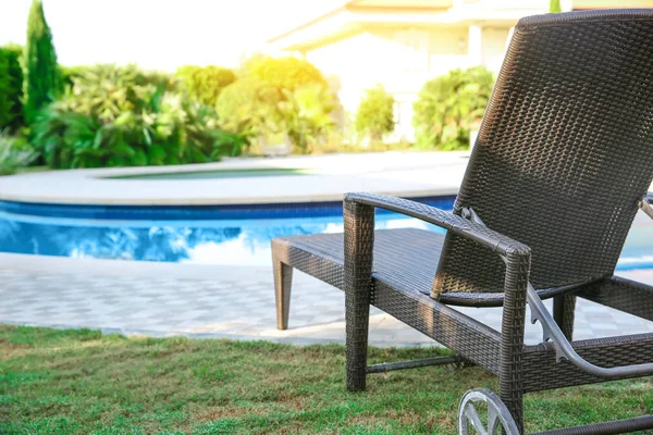 Comfortable sun lounger near swimming pool at resort — Stock Photo, Image