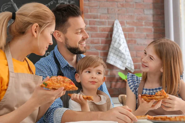 Keluarga makan pizza lezat bersama-sama di dapur. Konsep kelas memasak — Stok Foto