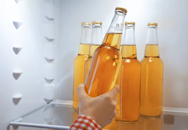 Woman taking a bottle of lemonade from open fridge — Stock Photo, Image