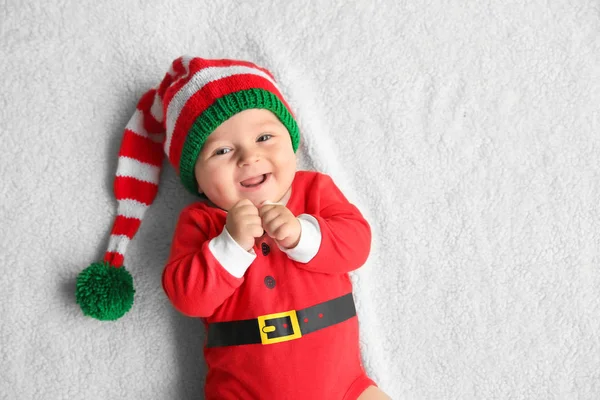 Schattige kleine baby in Santa kostuum liggend op zachte stof — Stockfoto