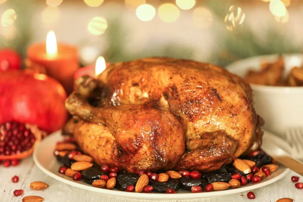 Placa con sabroso pavo asado entero en la mesa contra luces desenfocadas — Foto de Stock