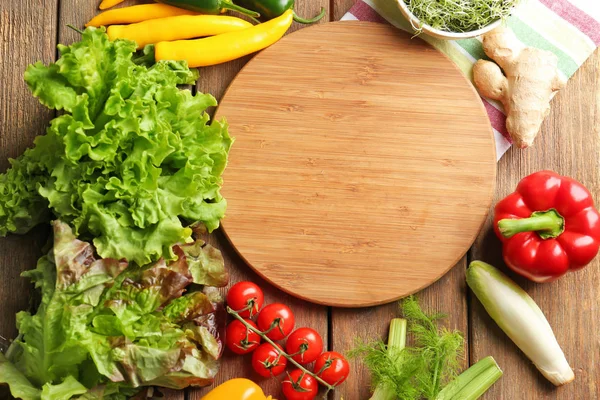 Drewniana deska i warzywa — Zdjęcie stockowe