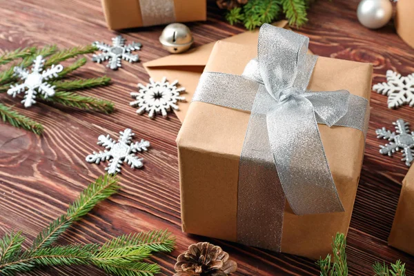 Подарочная коробка и рождественские украшения на деревянном столе — стоковое фото