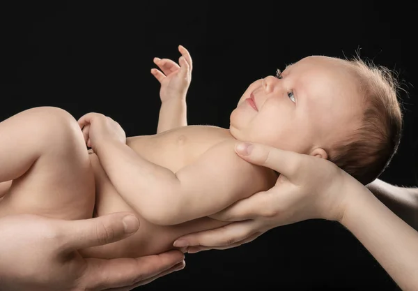 Rodiče drží novorozence na černém pozadí, closeup — Stock fotografie