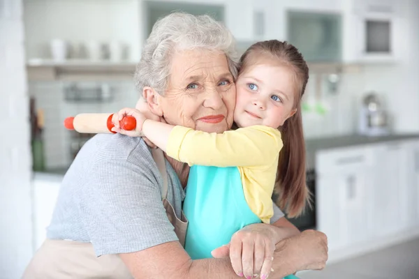 Маленькая девочка и бабушка на кухне — стоковое фото