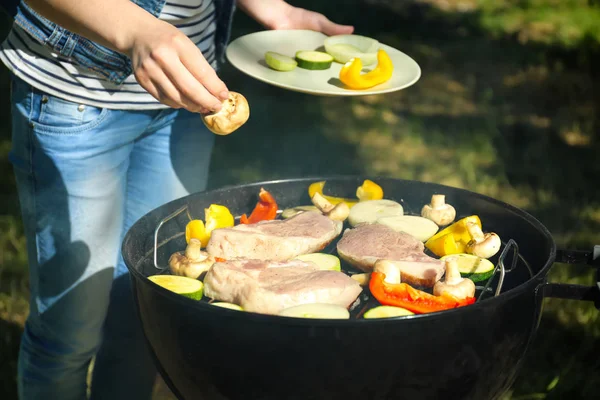 Donna che prepara bistecche barbecue — Foto Stock