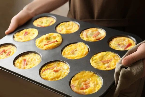 Vrouw met bakken schimmel met smakelijke ei muffins, close-up — Stockfoto