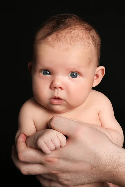 Vater hält Neugeborenes auf schwarzem Hintergrund — Stockfoto